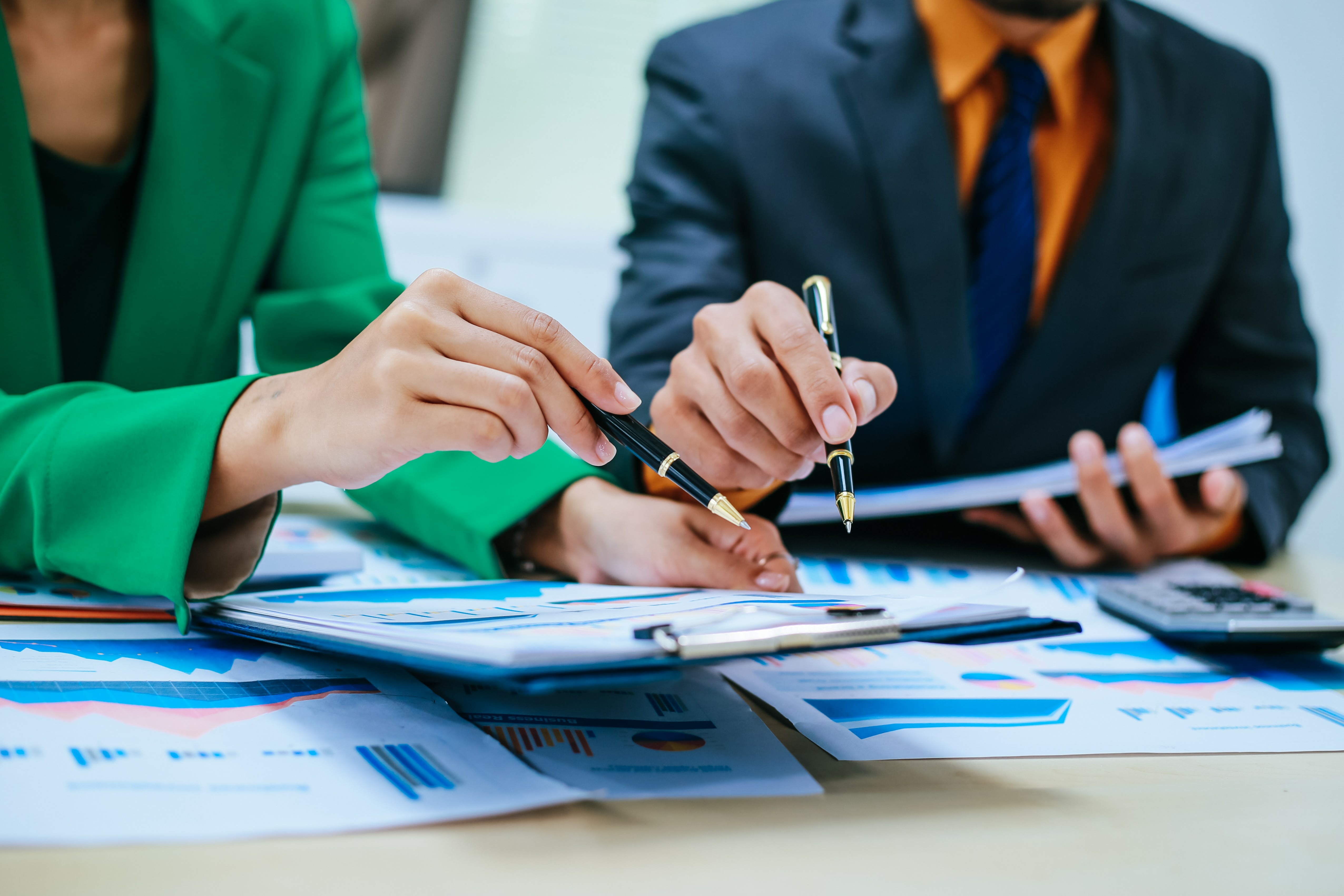 2 individuals meeting and discussing documents with graphs